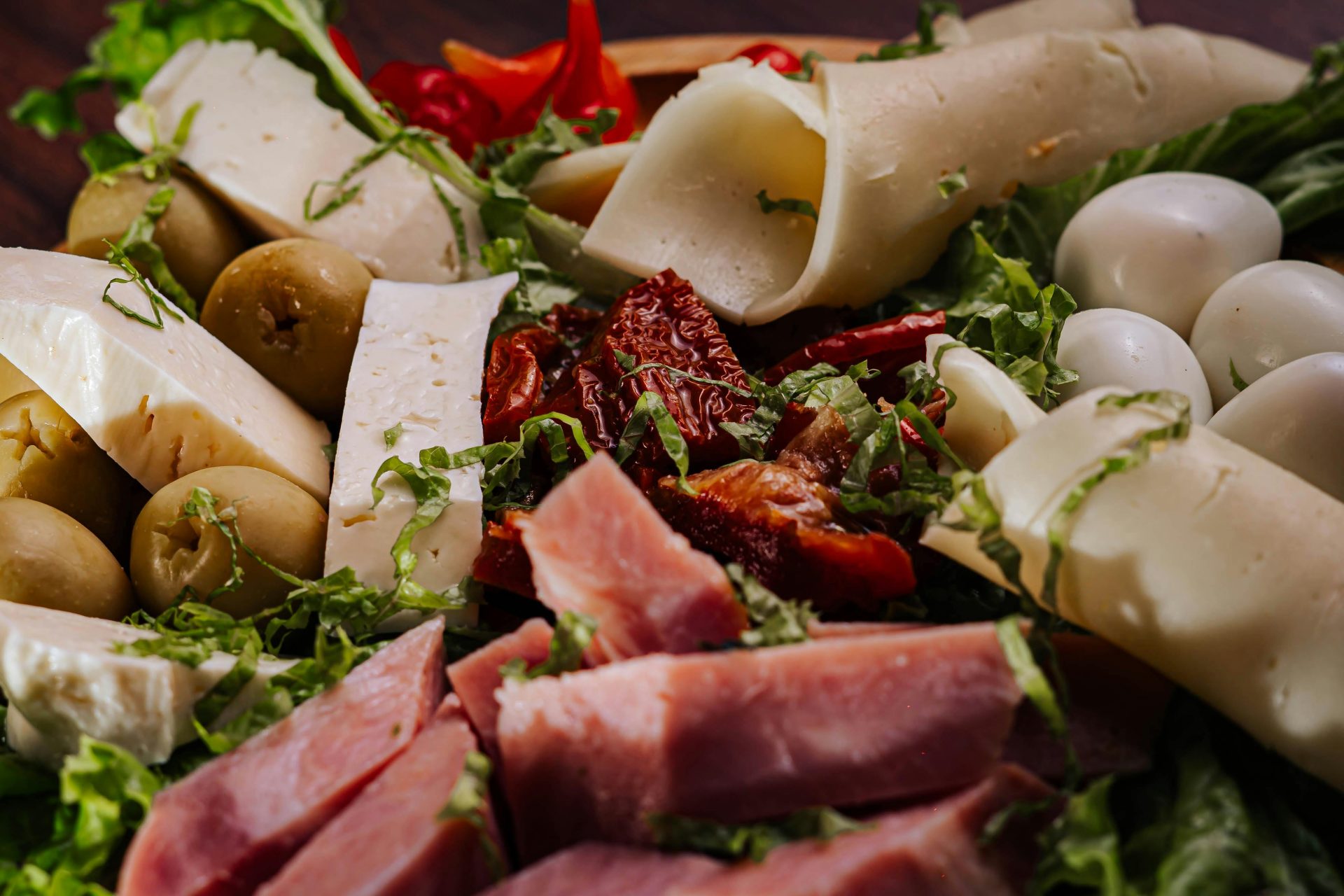 Köstliche Antipasti-Platte mit Käse, Fleisch, Oliven und Gemüse für eine perfekte Vorspeise.